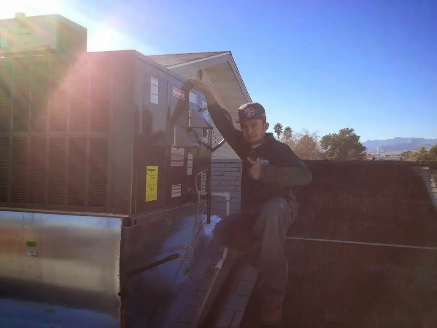 HVAC technician performing Boiler Repair on a rooftop unit in Lawrence